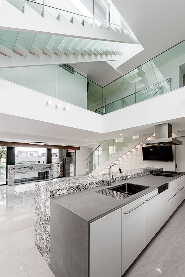 高級住宅│モダンな白いキッチンとガラスの階段