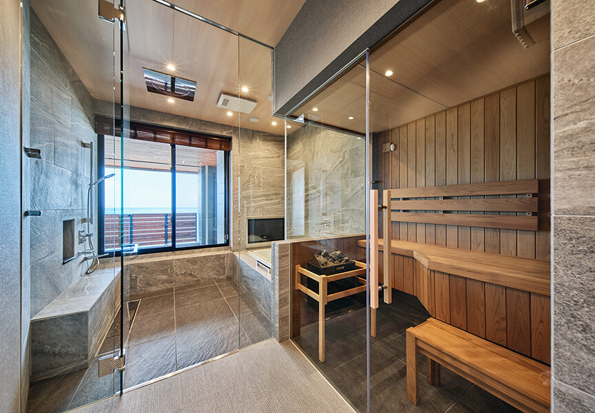 高級住宅のバスルーム。サウナ付きで海の見える石目調のバスルーム。