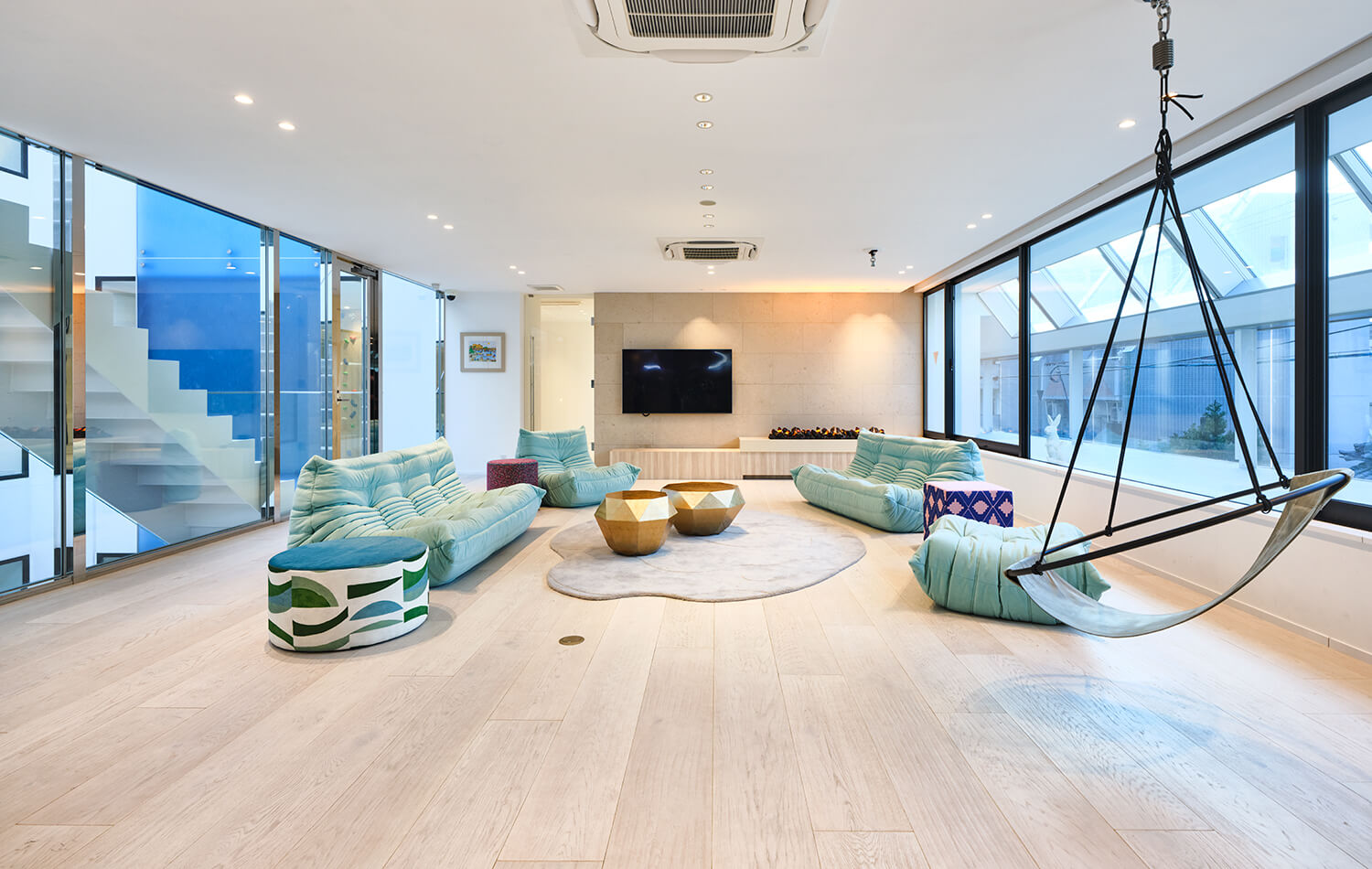 高級住宅のインナーテラスリビング。２面を開口とした開放的な室内。開口からパティオの滝を望む。