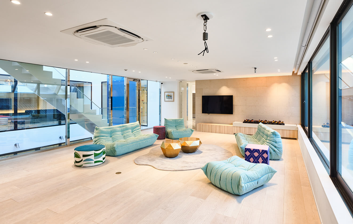 高級住宅のインナーテラスリビング。２面を開口とした開放的な室内。開口からパティオの滝を望む。