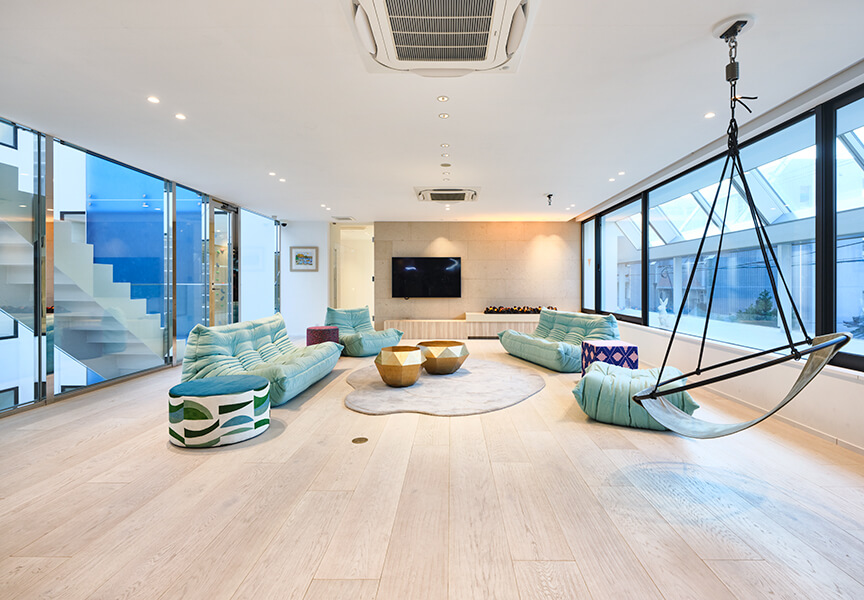 高級住宅のインナーテラスリビング。２面を開口とした開放的な室内。開口からパティオの滝を望む。